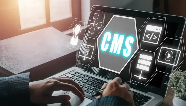 Person, die einen Laptop benutzt, auf dem eine CMS (Content Management System)-Benutzeroberfläche auf dem Bildschirm projiziert ist.